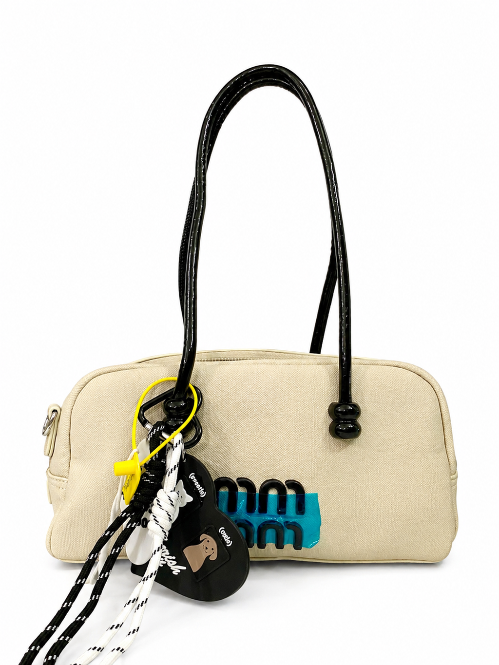 A premium Elegant Canvas Mini Handbag with Glossy Handles & Charm Accessories – Beige